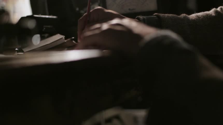A man does some writing on a desk