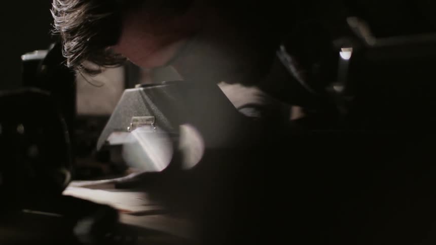 A man works looks closely at a book with a machine