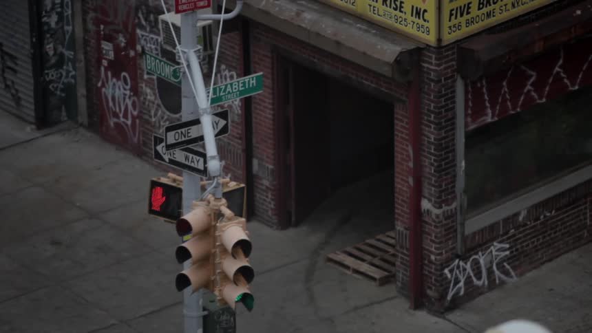 A person walks by a corner with signals and street signs