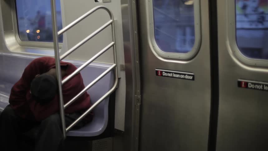 A man sleeps on a train in the evening