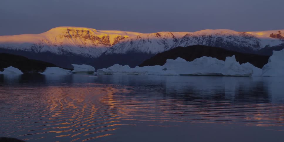 Sunset reflects off the water and distant mountain range