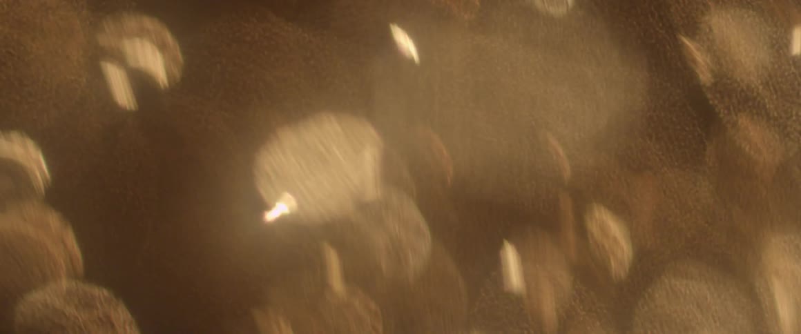 Odd potato chip shaped lights bouncing up and dissipating into the air, along with other odd shaped lights