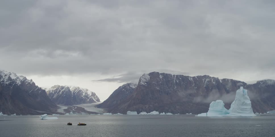 View of a boat on a lake with a mountain and glacier in the background
