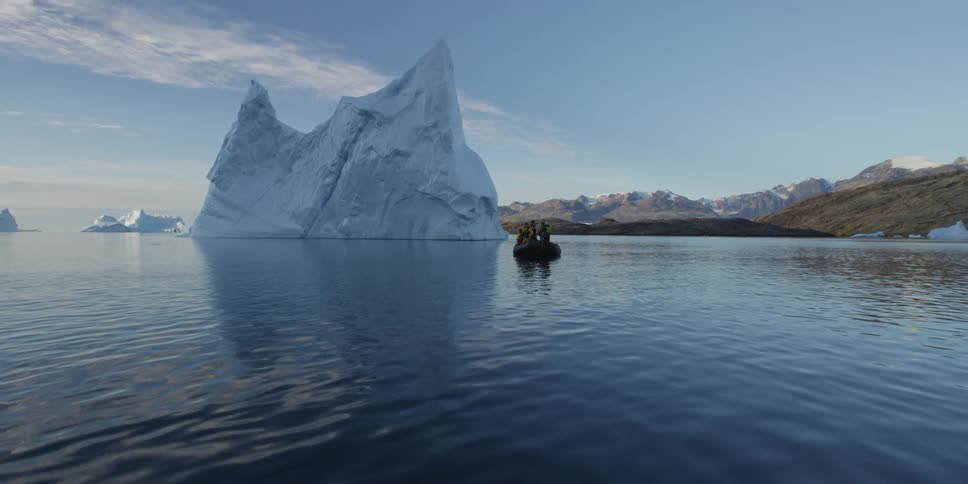 People in a boat near an iceberg