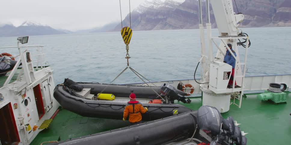 A crane lifts an inflatable boat