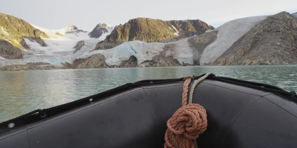 A raft floats towards snow-covered mountains