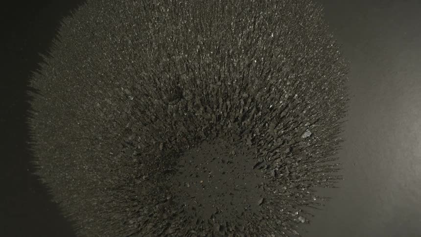 Powder falls onto a smooth powdered surface creating lines and divots