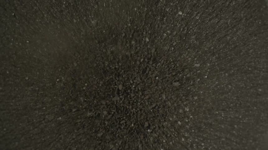 Dark brown grainy material coming to settle