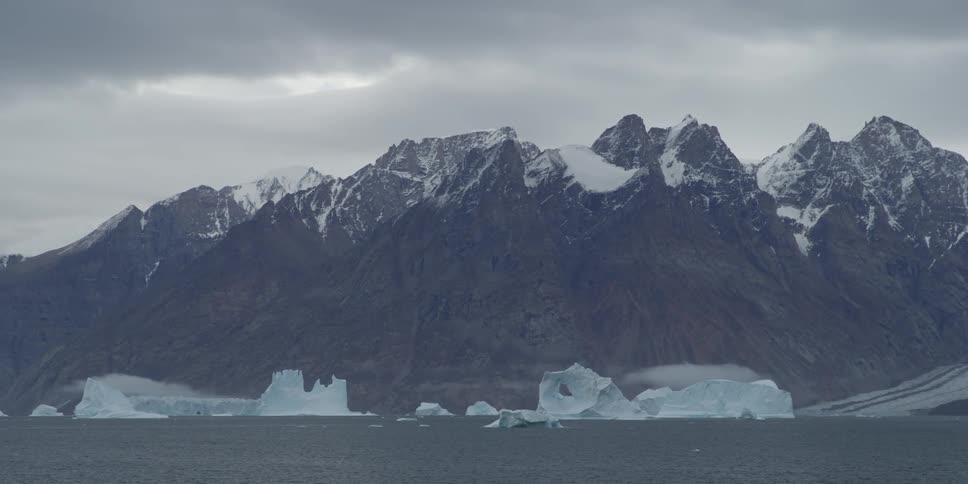 A distant view of snow-capped mountains and icebergs