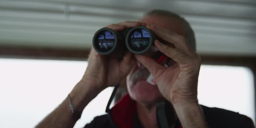 A man looks through binoculars