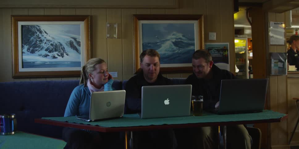 People sit at a table with their laptops