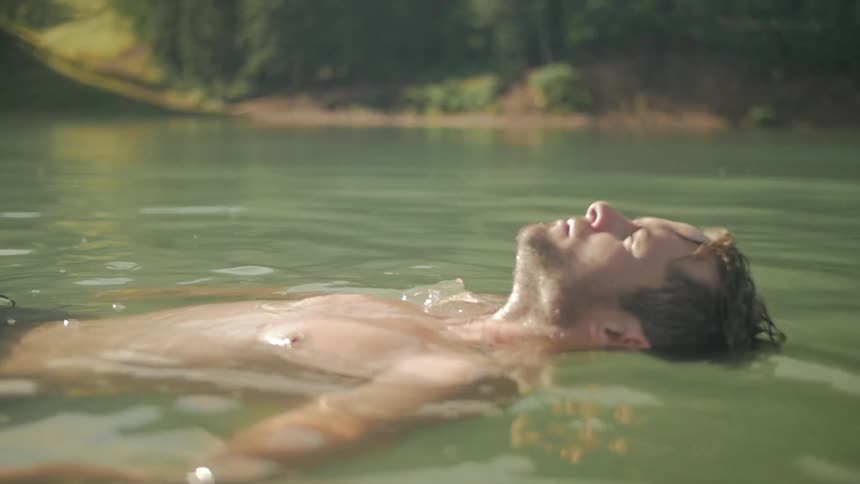A man floats in a lake during the day