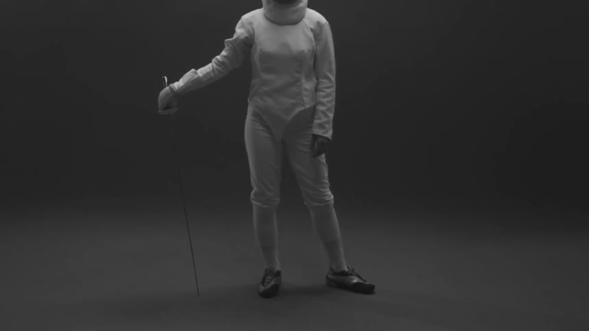 Person standing in a fencing outfit with their sword