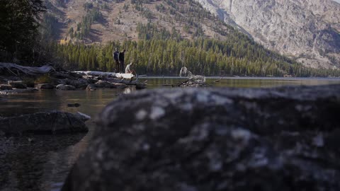 People stand on rocks near a river