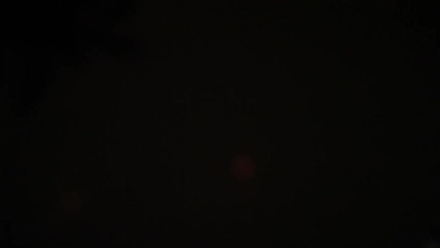 Fireworks exploding in the sky while two people admire them