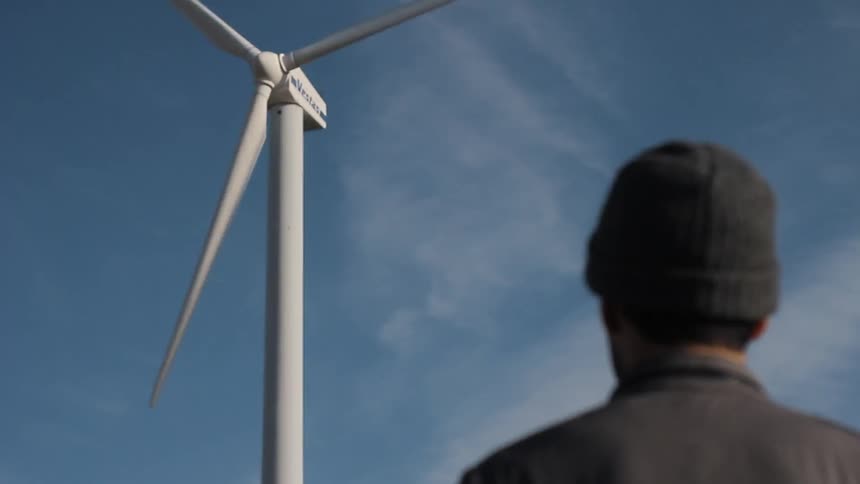 A man watching a wind turbine