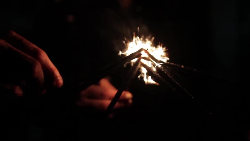 A group of people light sparklers together