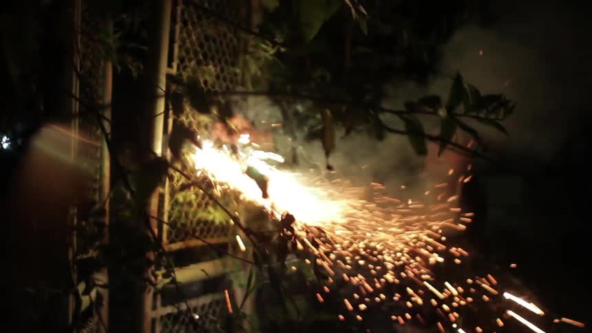 A man lighting a sparkler on a roman candle