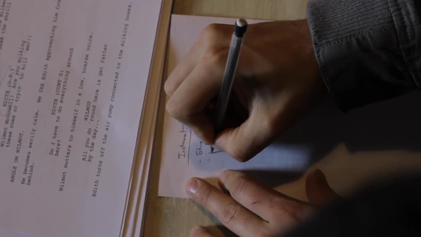 Person writing some notes on a desk