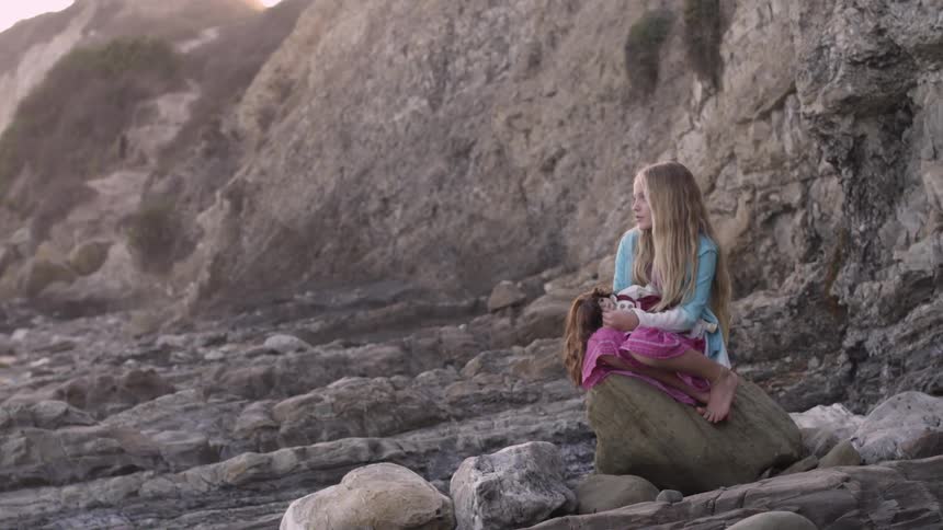 A girl sitting on a rock