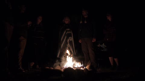 A group of people in front of a small fire