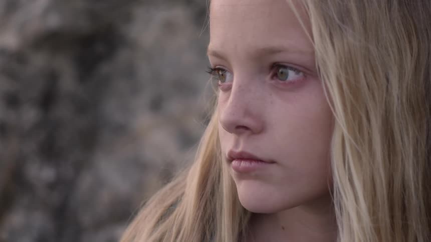 A blonde girl looks into the distance