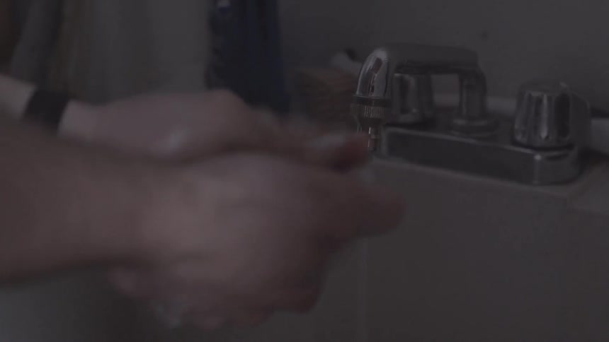 A man washing his hands in a sink