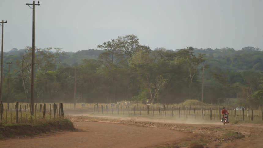Man riding bicycle down dirt path