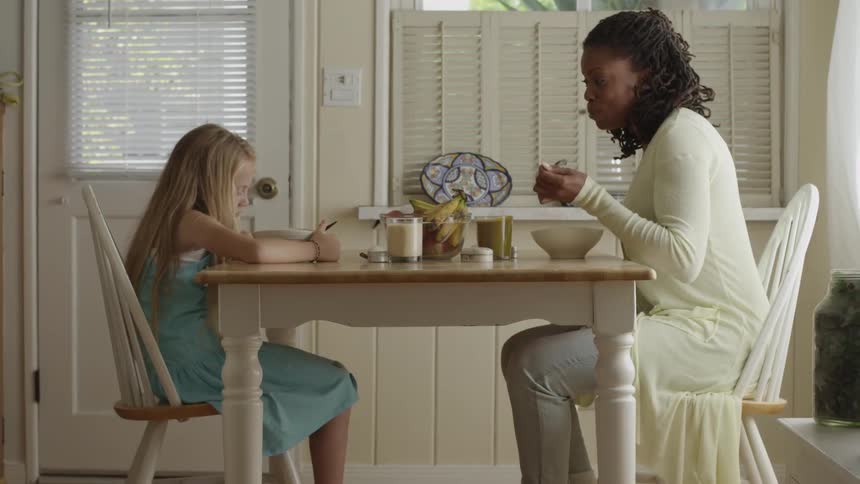 A woman and a girl sitting at a table