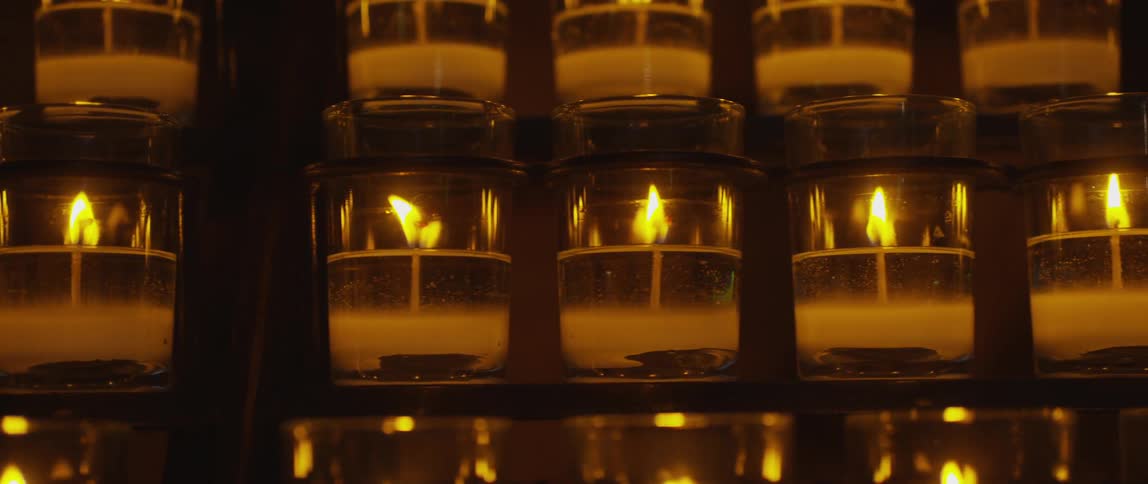 Lined up candles flicker and burn