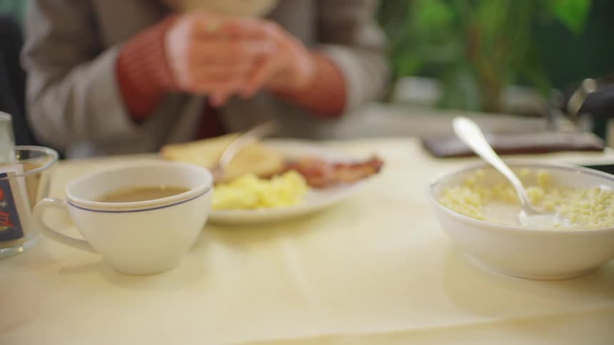 A couple sitting at a table with plates of breakfast food in front of them