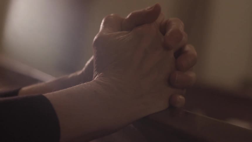 A older person holding onto a railing