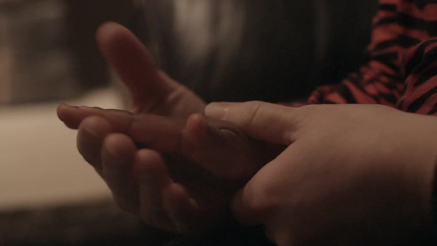 An adult and child  holding hands