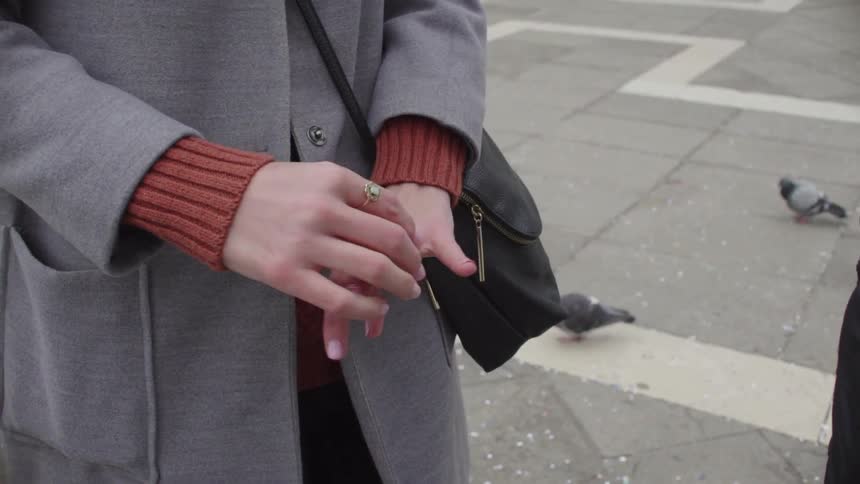 Woman plays with rings on her hands outside