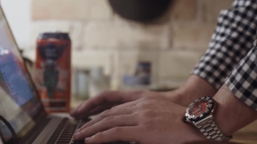 A man types on a laptop