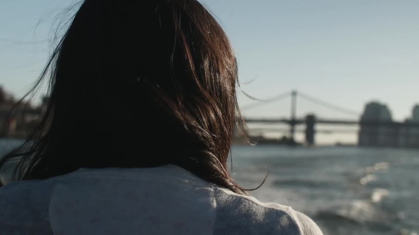 A woman's hair blows while riding in a boat