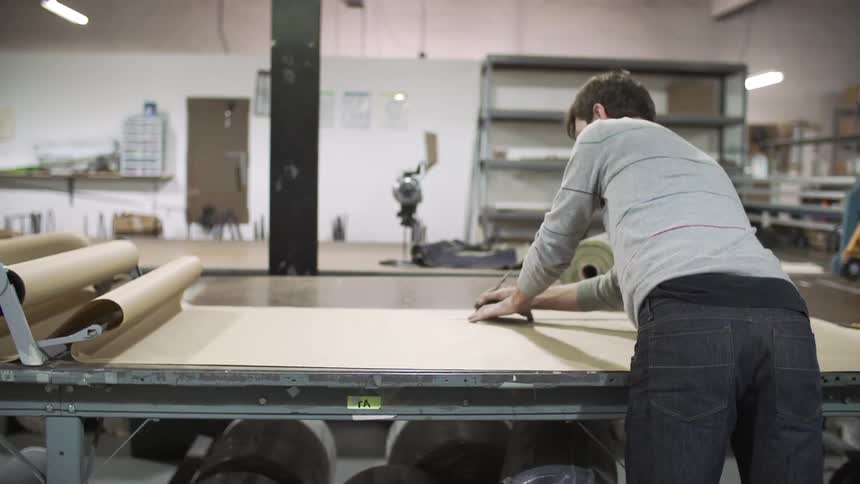 A man measures brown paper