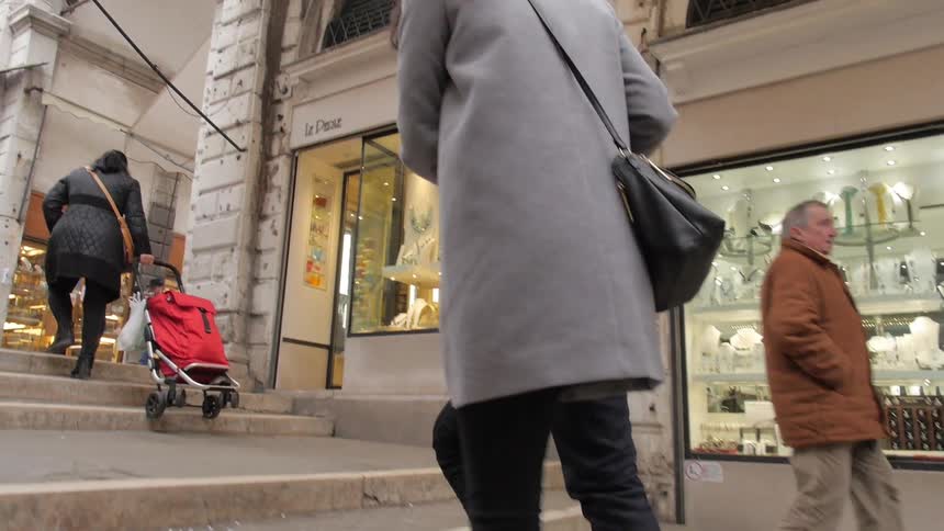 People walking up some steps to a sidewalk by buildings