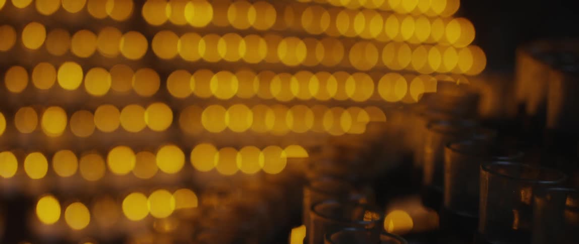 A view of unlit candles in front of blurry lit candles