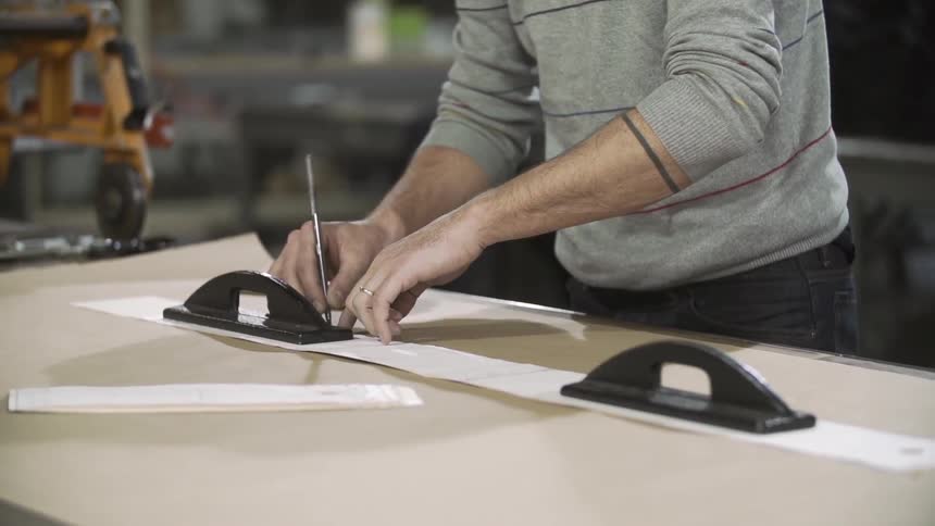 A man traces on a large piece of paper