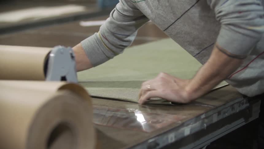 Workers spreading fabric on a machine in a factory