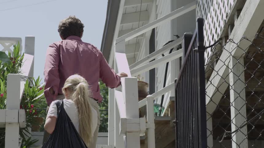 A man and a child walk up steps