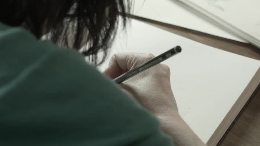 Person writing in a book sitting at a desk