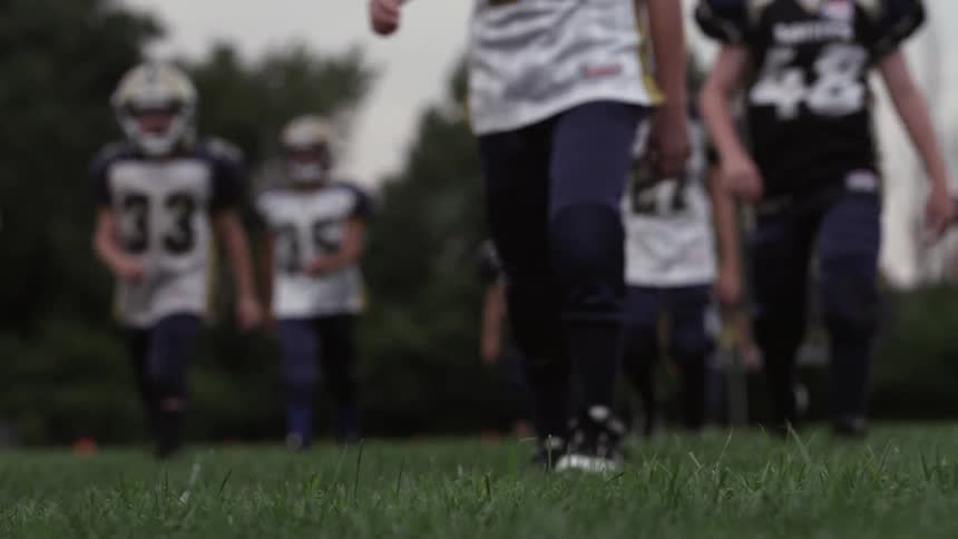 A group of boys walk across a football field