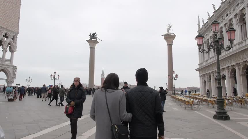 A couple walks through a busy area