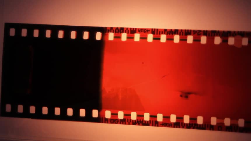 A person is looking at old camera negatives