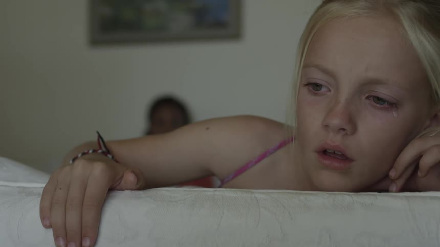 A tear flows down a girl's cheek