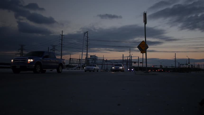 Cars traveling down a road at sunset