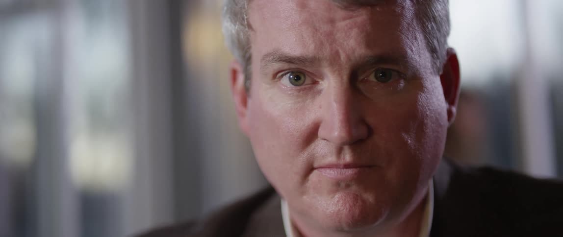 Man looking down and then staring forward in a business suit