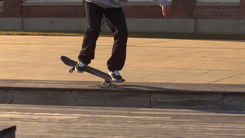 A skateboarder jumps onto a ledge
